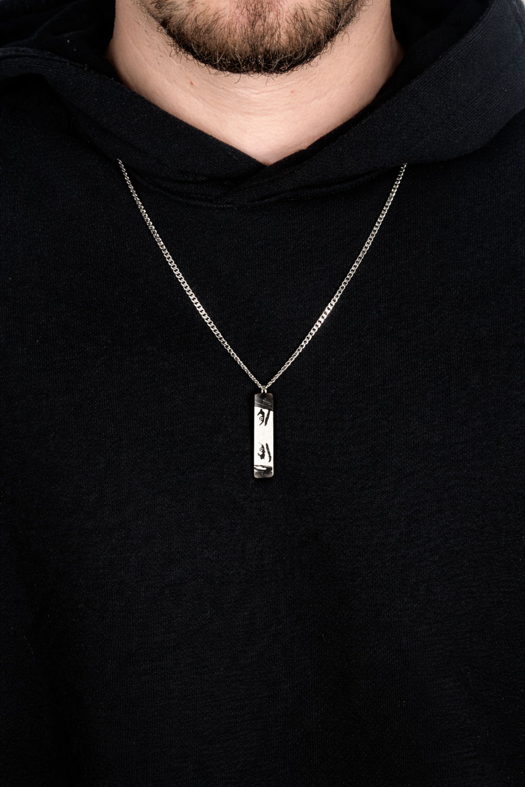 a man is wearing an engraved necklace with real eyes from real photo