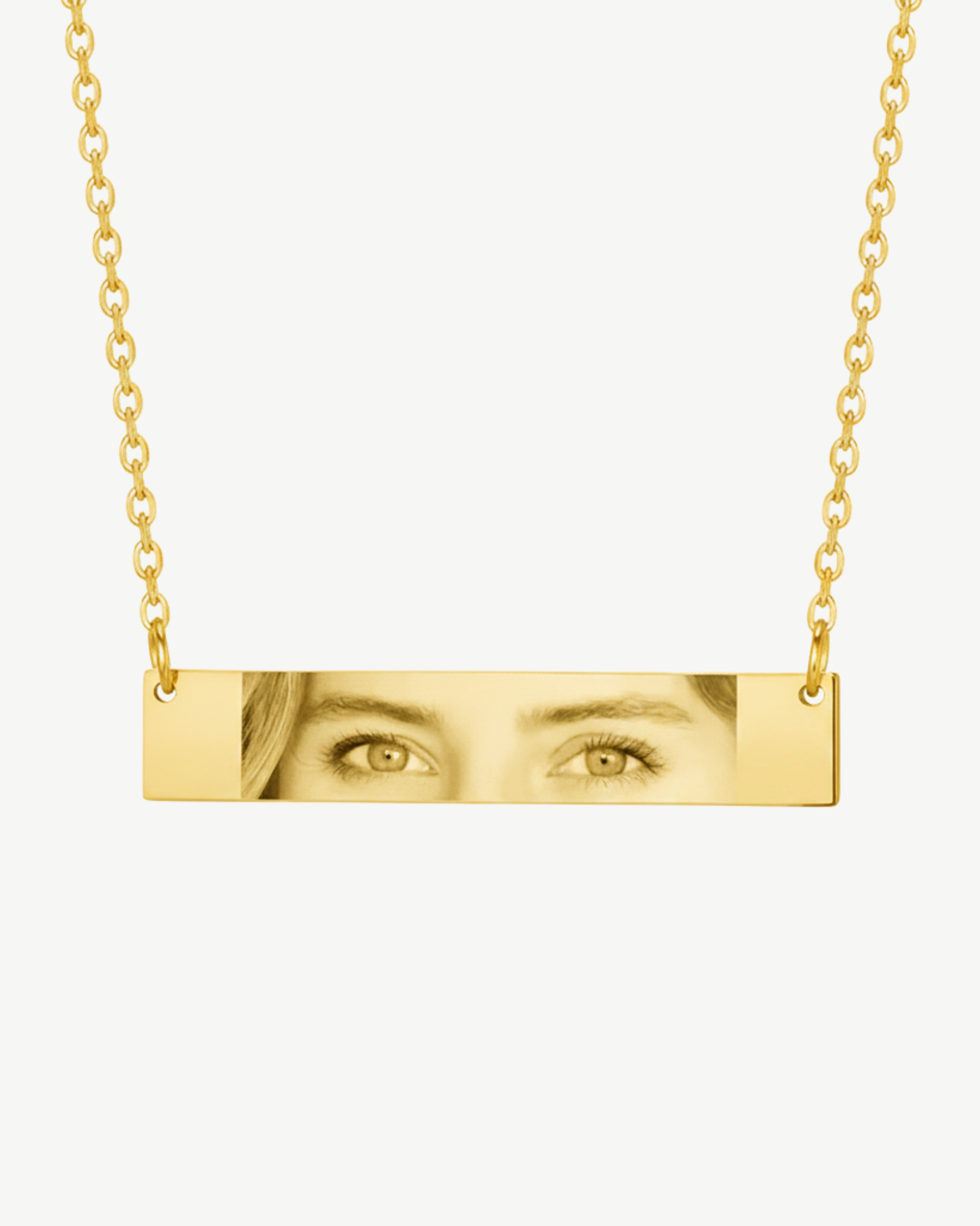 Personalized gold eye photo necklace with black and white engraved image on bar pendant