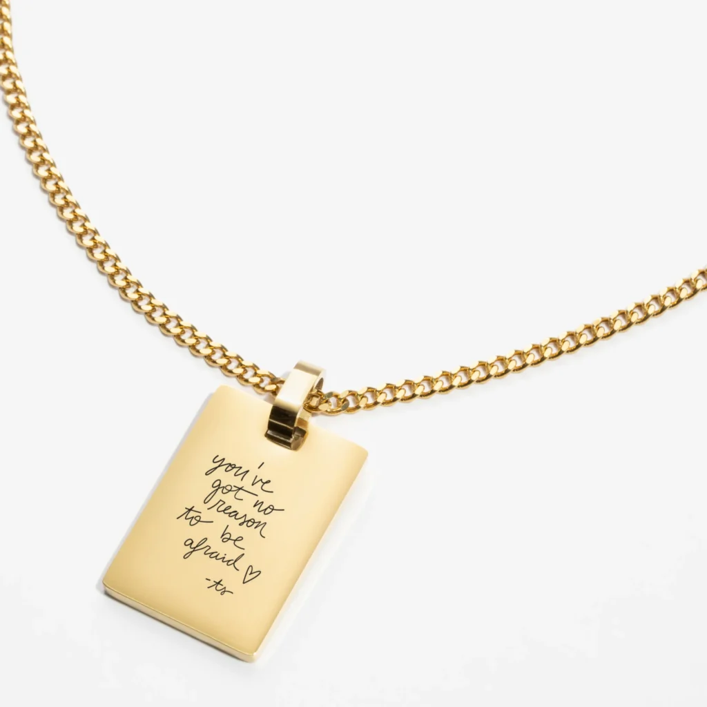 A close-up of a custom necklace featuring intricate handwriting engraving, highlighting its fine details and craftsmanship.