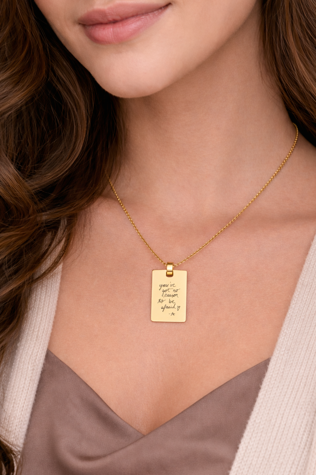 A model wearing a custom necklace with a handwritten engraving, showcasing its delicate design and personal significance.