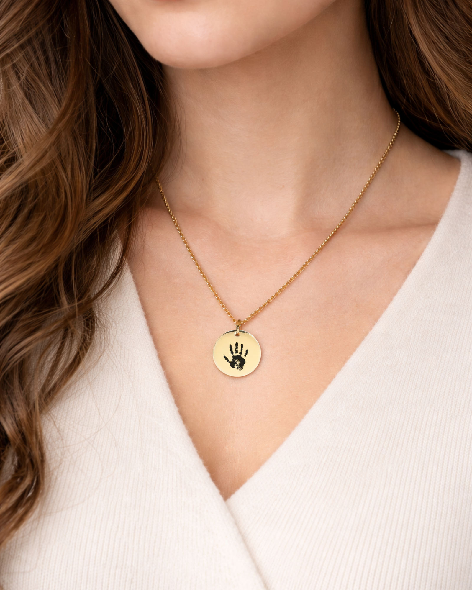 Mother wearing engraved baby handprint necklace as sentimental keepsake