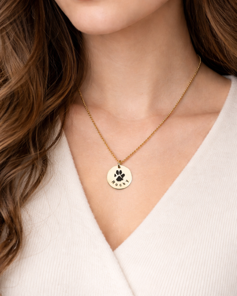 Woman wearing custom dog paw print necklace as pet memorial jewelry