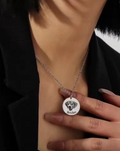 A personalized dog portrait photo necklace in gold, featuring an engraved image of a beloved dog
