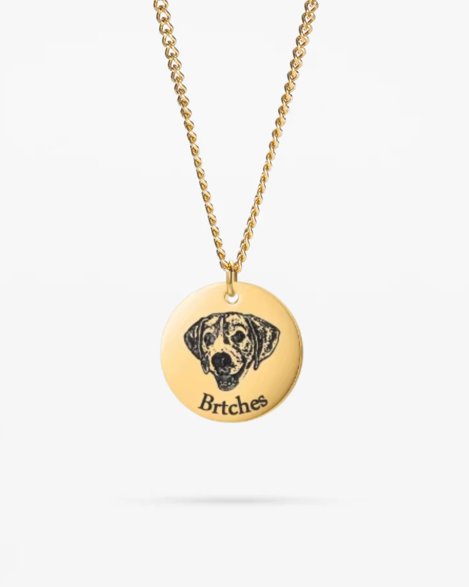 A personalized dog portrait photo necklace in gold, featuring an engraved image of a beloved dog
