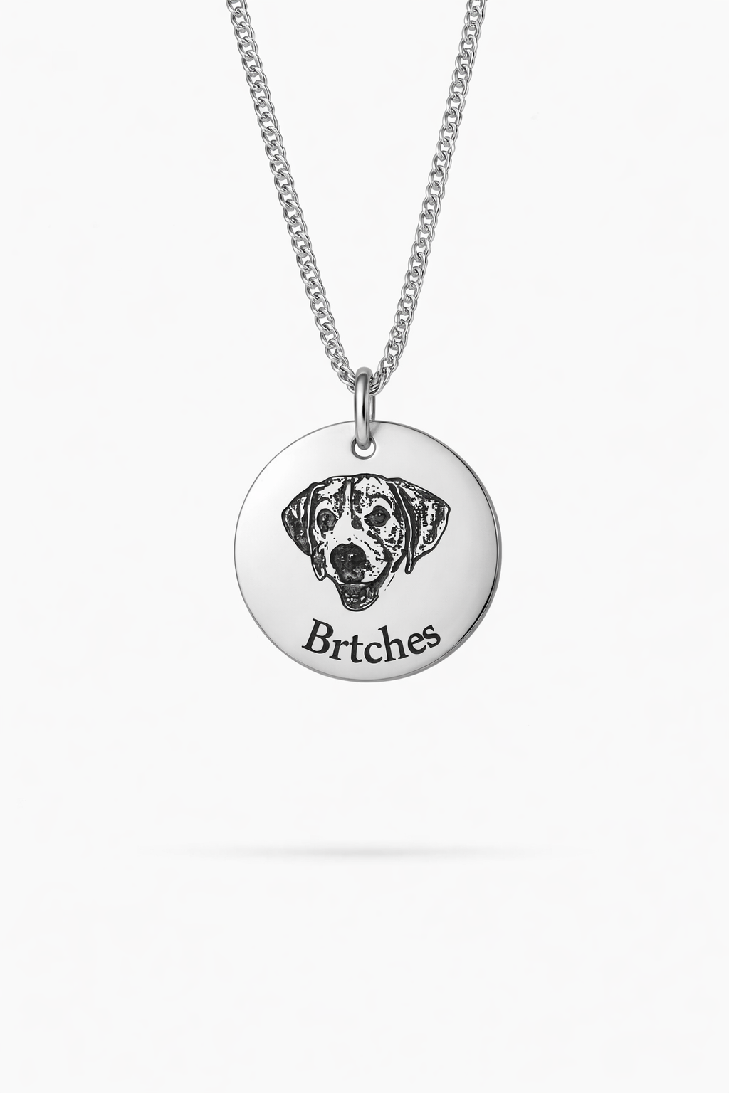 A custom sterling silver dog portrait necklace, showcasing a detailed engraving of a pet's image.
