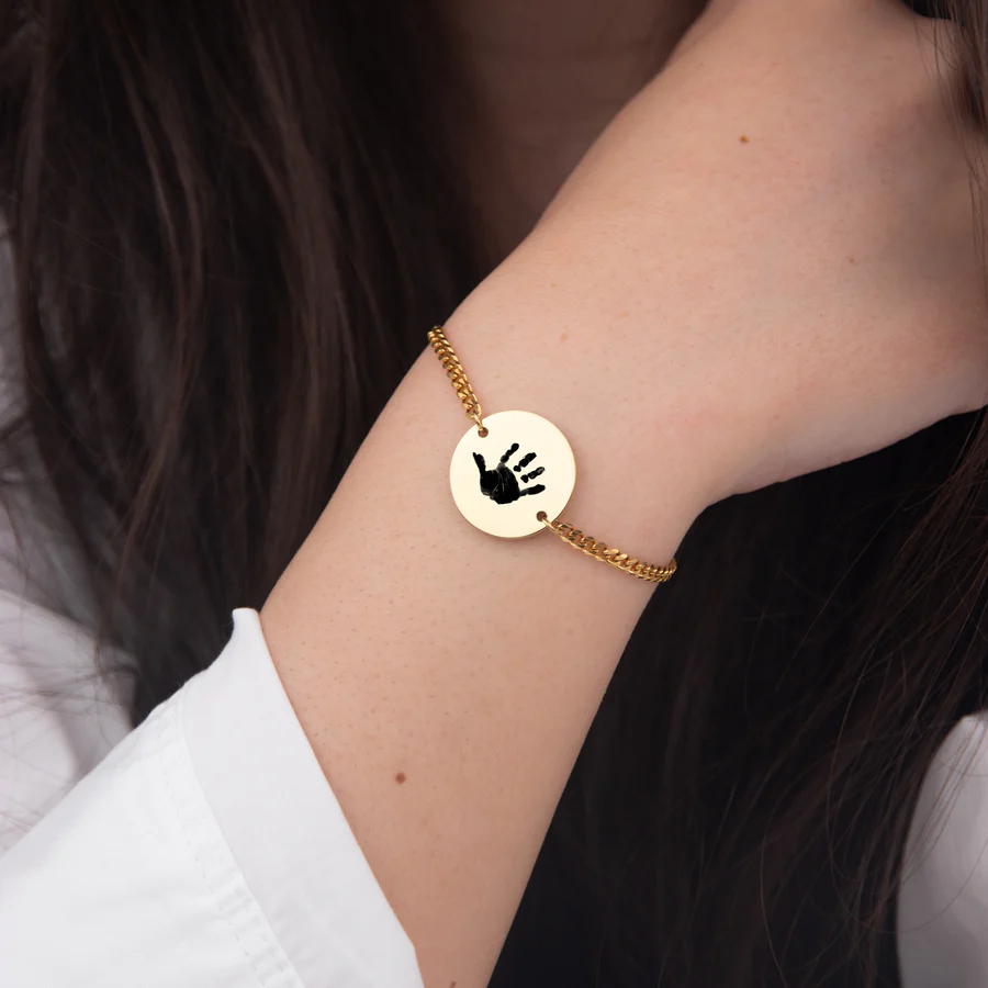 Woman wearing a custom baby handprint bracelet on wrist