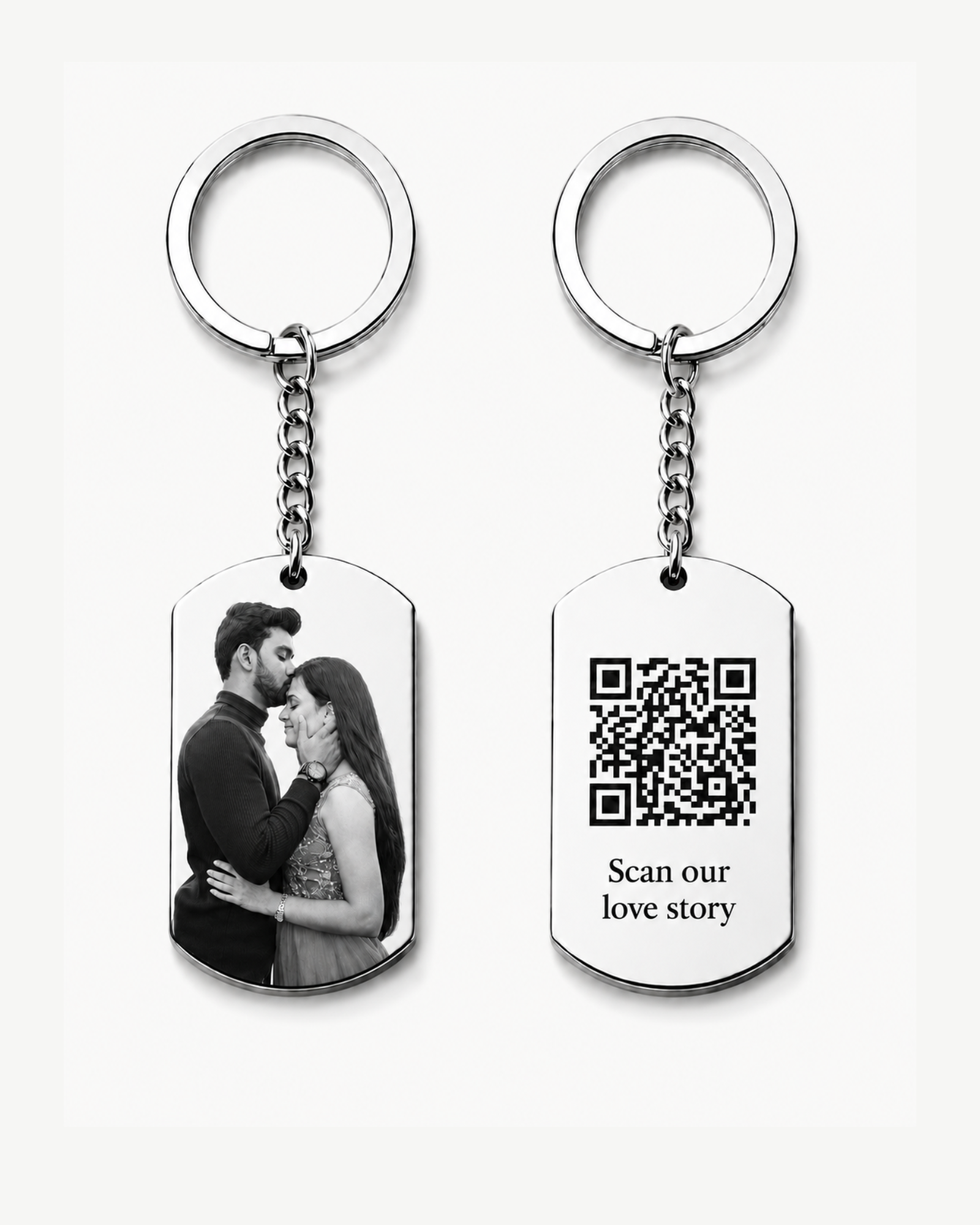 Hidden Message Photo Keychain: Two silver keychains displayed on a clean light background. One rectangular pendant features a black-and-white couple photo, and the other pendant shows a QR code with the words “Scan our love story.