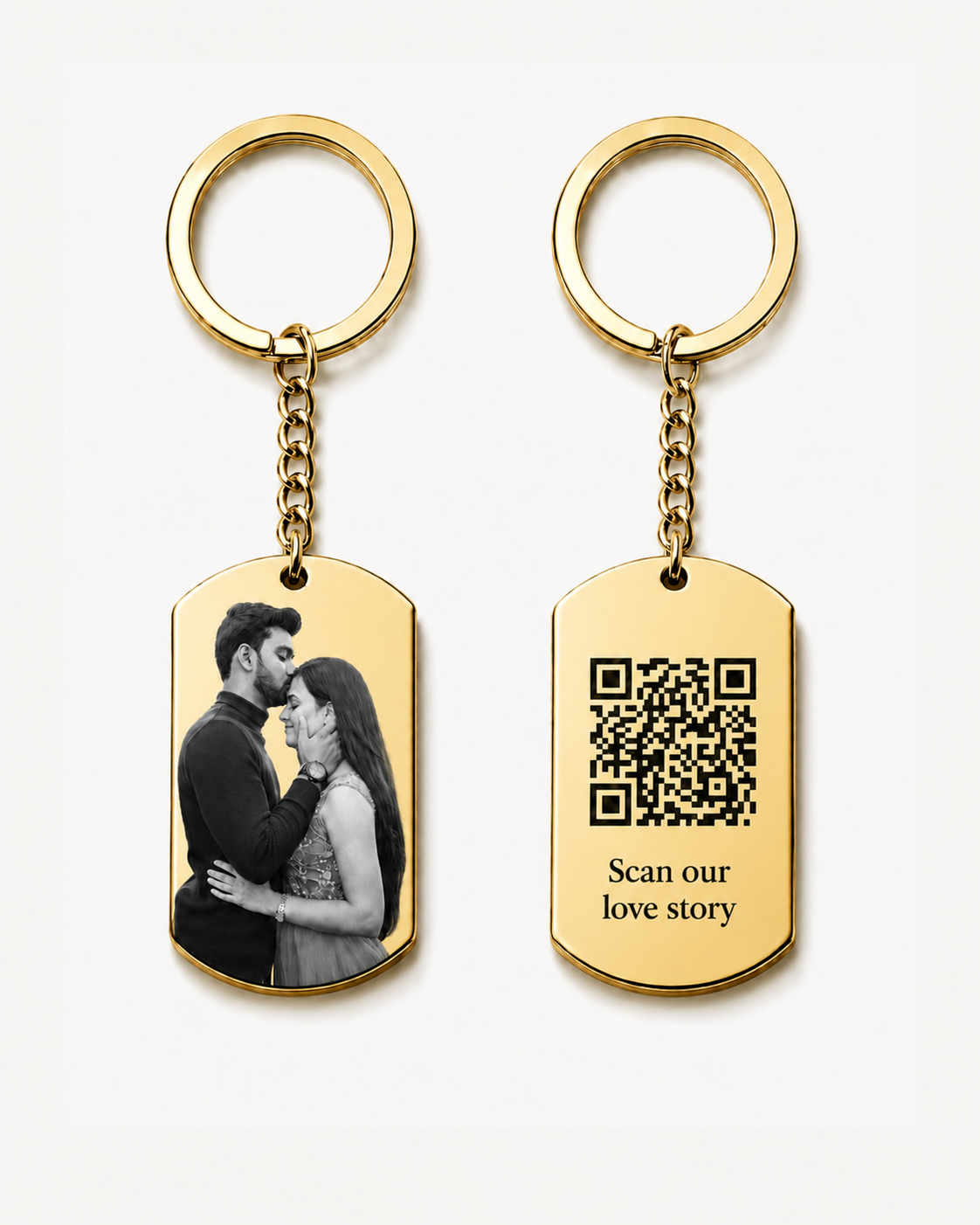 Two gold keychains displayed on a clean light background. One rectangular pendant features a black-and-white couple photo, and the other pendant shows a QR code with the words “Scan our love story.