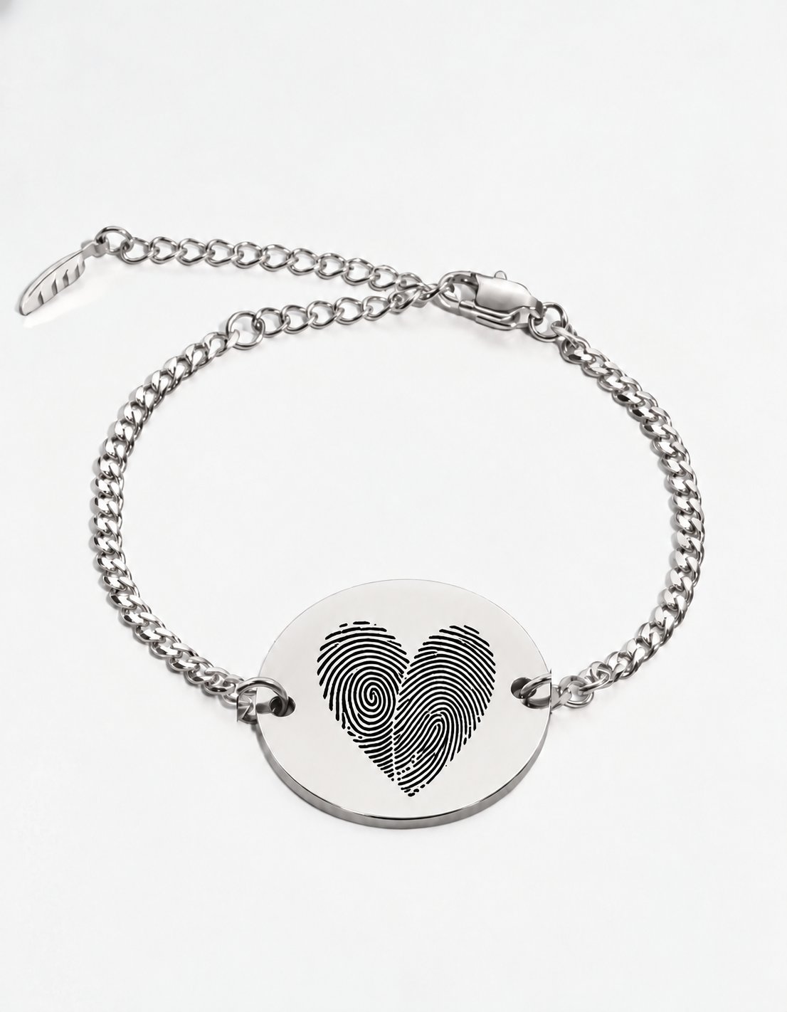 Two fingerprint bracelet in silver — two actual fingerprints engraved as a heart on a round disc, Cuban chain bracelet with lobster clasp and extender. Personalized couples fingerprint bracelet in stainless steel.
