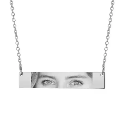 Silver chain necklace with a rectangular pendant displaying a black and white photo of a person’s eyes