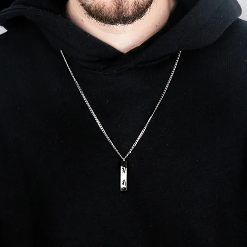 a man is wearing an engraved necklace with real eyes from real photo