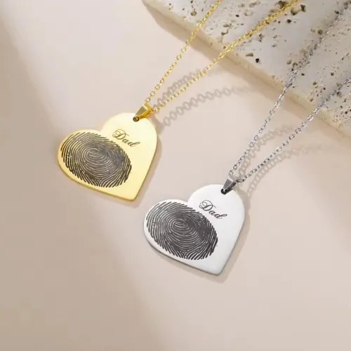 Heart-shaped fingerprint gold and silver necklaces showing detailed engraving, ideal for baby or memorial keepsake jewelry.