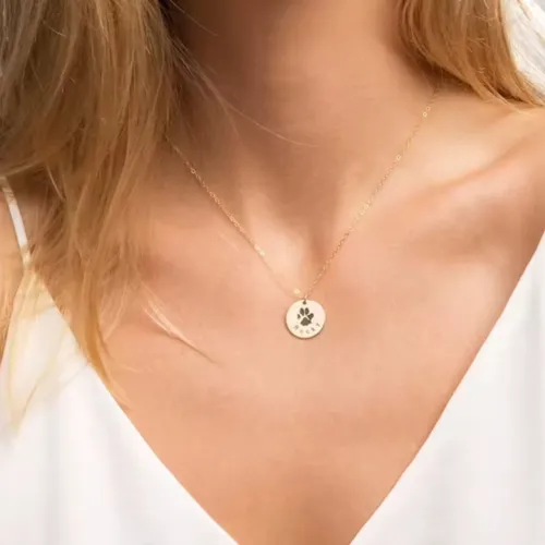 Woman wearing custom dog paw print necklace as pet memorial jewelry