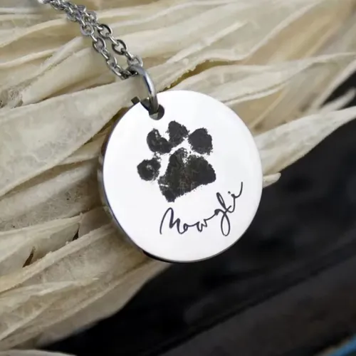 Personalized pet paw print pendant close-up showing engraving