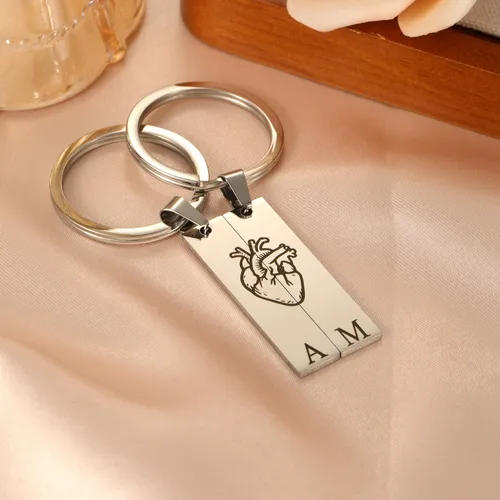 Personalized split heart keychains displayed in gold and silver stainless steel finishes.